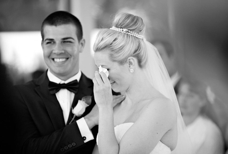 bride crying, groom smiling.