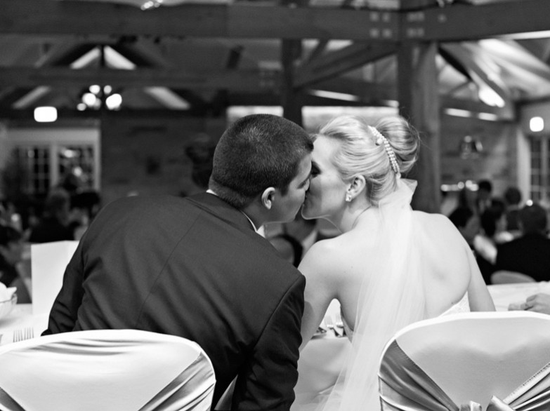 bride and groom sneak a kiss.