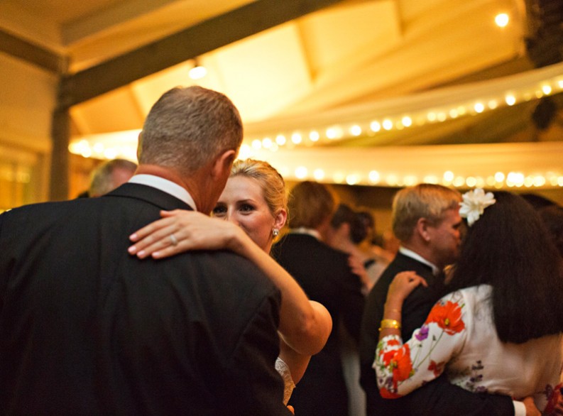 bride peaks over father's shoulder